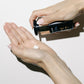 Intuisse Active NAD+ Peptide Essential Cream being pumped into the palm of a hand.