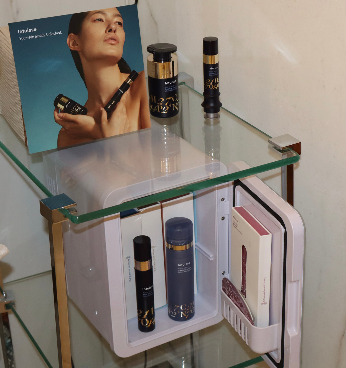 Intuisse skincare fridge displayed on a glass shelf with the Active NAD+ range a intuisse leaflet