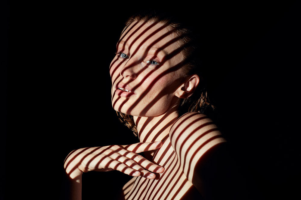 Model cast in light through blinds